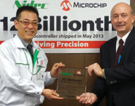 Hitoshi Tatsuno of Nidec Corporation receives the 12 billionth PIC microcontroller trophy from Joe Krawczyk of Microchip Technology.